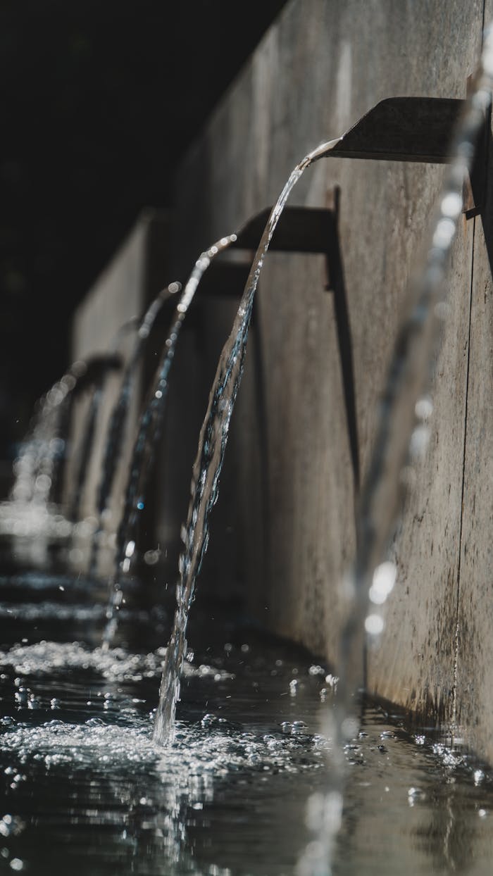 Close-up view of cascading water streams from a fountain on a sunny day.